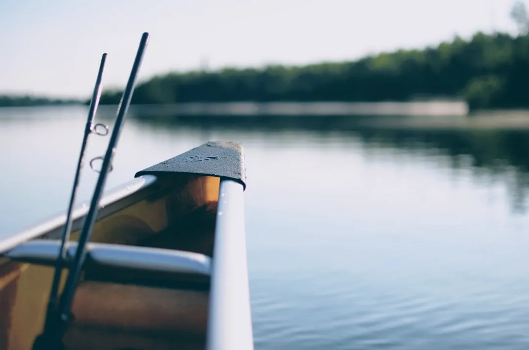 Kayak angler with rod ready in scenic water setting
