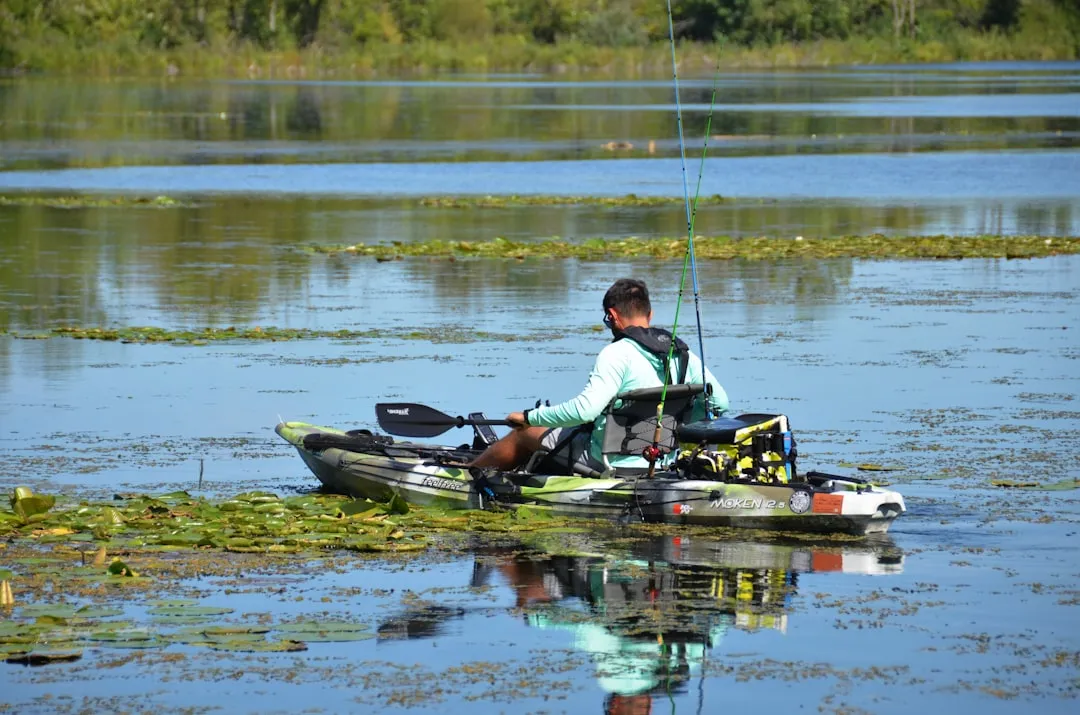 Kayak fishing on a wide river with scenic surroundings