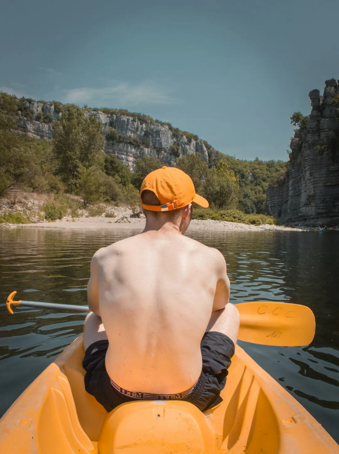 A kayaker sitting peacefully on calm water at sunrise