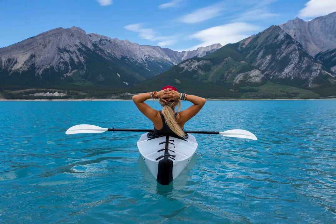 A kayak paddle cutting through crystal-clear water