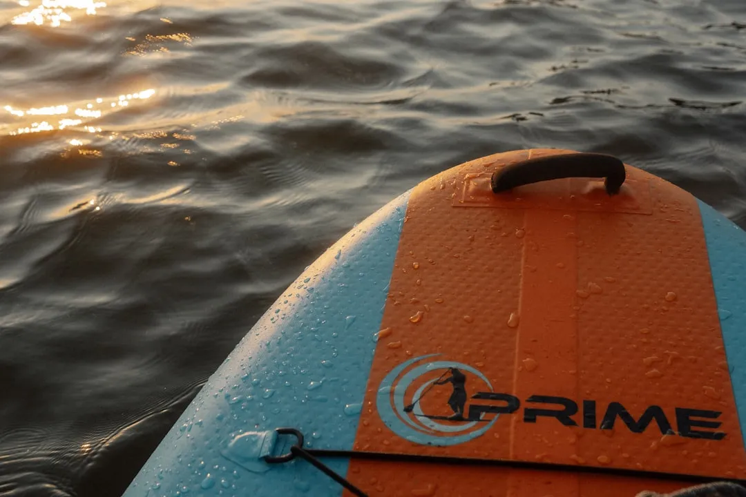 Paddle board being inflated on beach