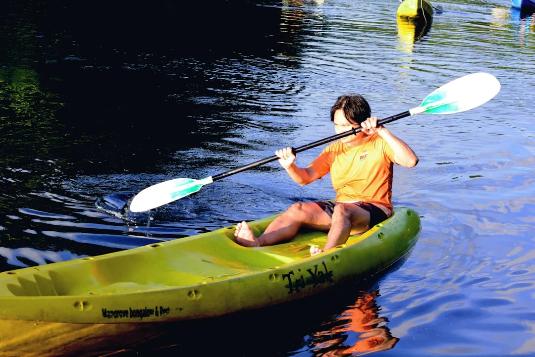 Parent and child kayaking together on calm lake