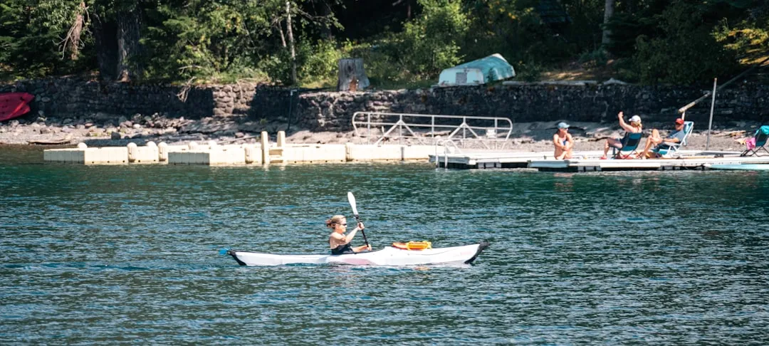 Parent and child practicing paddle strokes on calm water