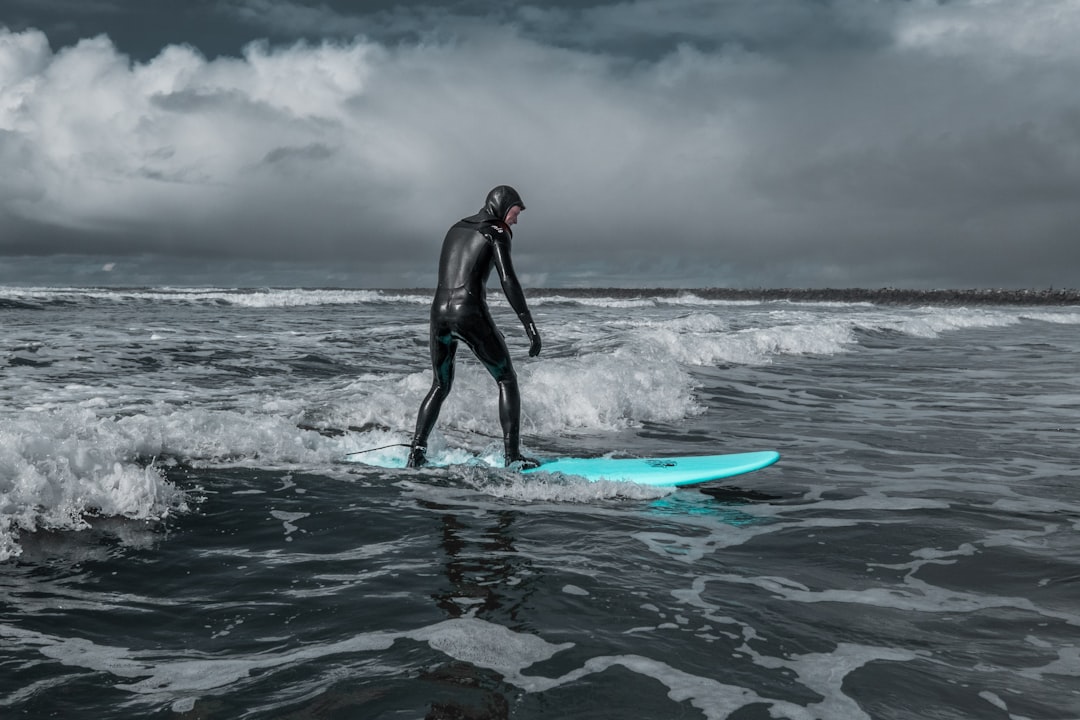 A paddle boarder navigating through choppy and windy water conditions.
